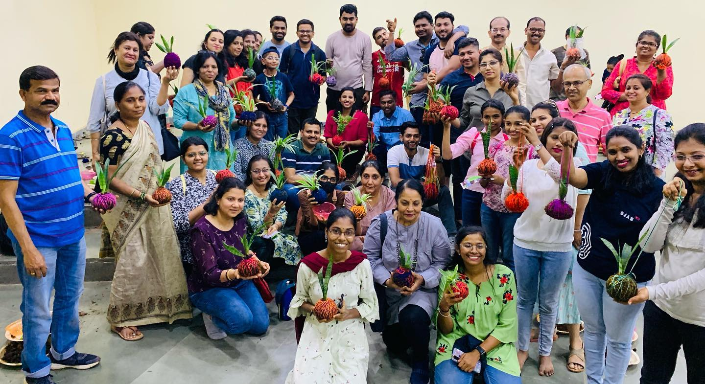 People holding up their Kokedama Workshop plants at Maharashtra Nature Park